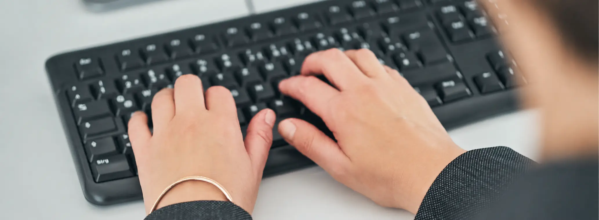 Tastatur, auf der getippt wird, sichtbar sind die Hände